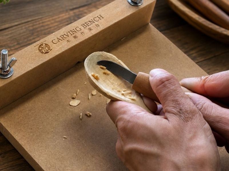 Carving a wooden spoon bowl with the scooping knife